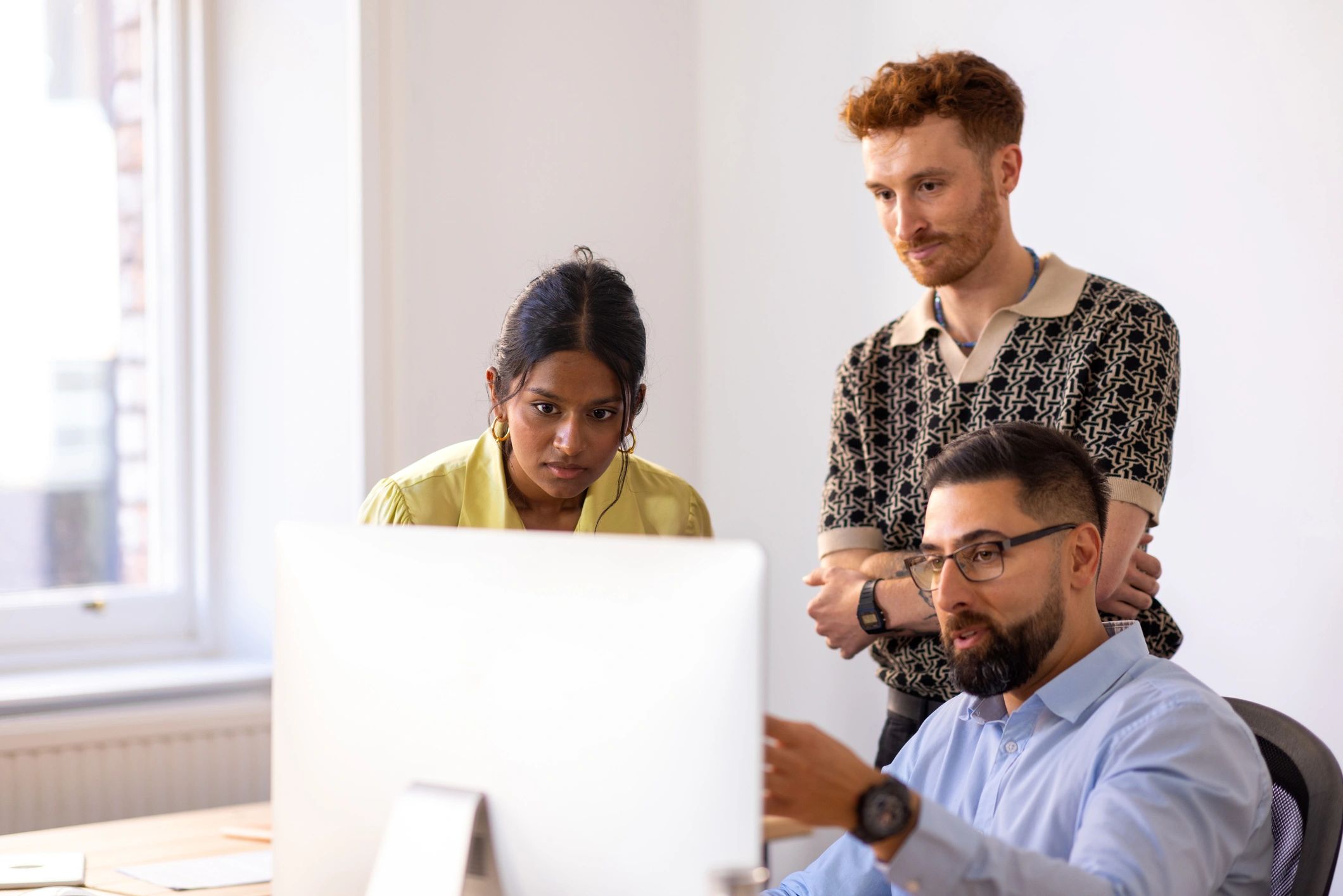 Team reviewing web development work on a computer